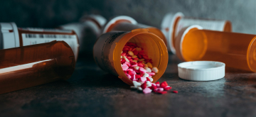 Medicatie in een gevallen potje op tafel