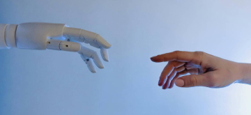 robothand dat reikt naar een mensenhand