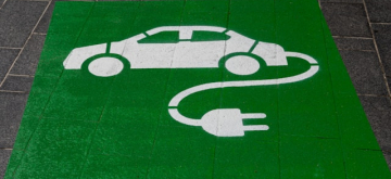 Groen vlak met afbeelding van witte auto met oplaadkabel