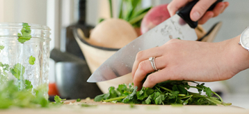 vrouw snijdt kruiden in de keuken