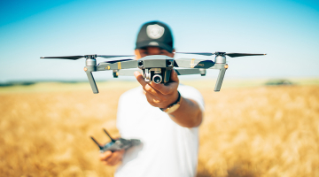 man met drone tussen landbouwgewassen