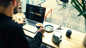 man drinkt koffie met laptop in café in Brugge