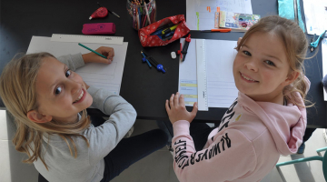 Twee kinderen tekenen plan voor droommachine