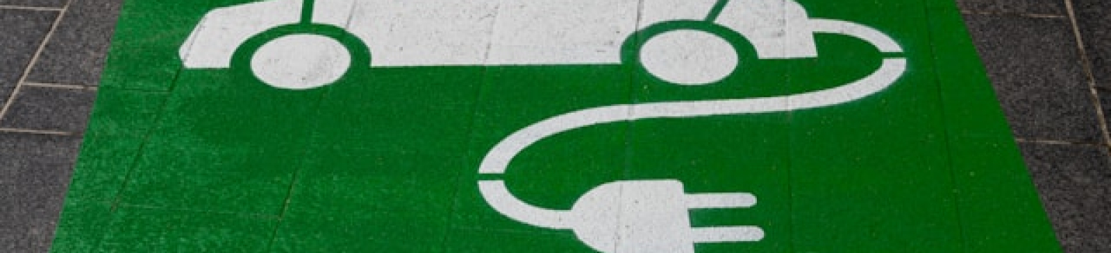Groen vlak met afbeelding van witte auto met oplaadkabel