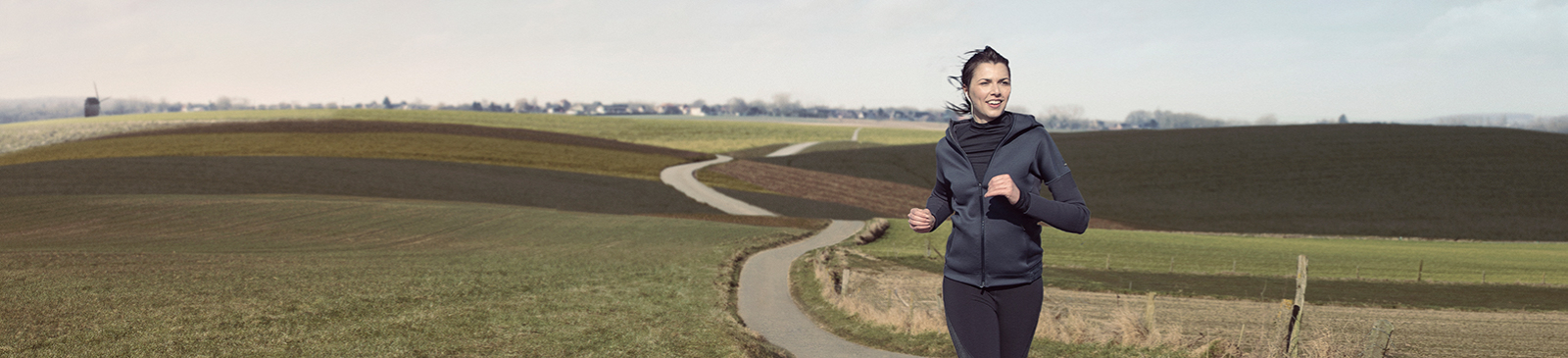 Vrouw jogt door open landschap